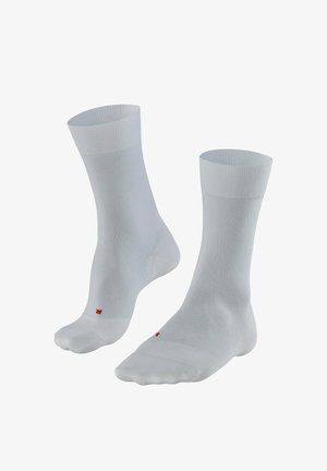 Paire de chaussettes blanches montantes jusqu'à la cheville avec compartiments séparés pour le gros orteil, marquées de petites lettres rouges "L" et "R" pour les pieds gauche et droit.