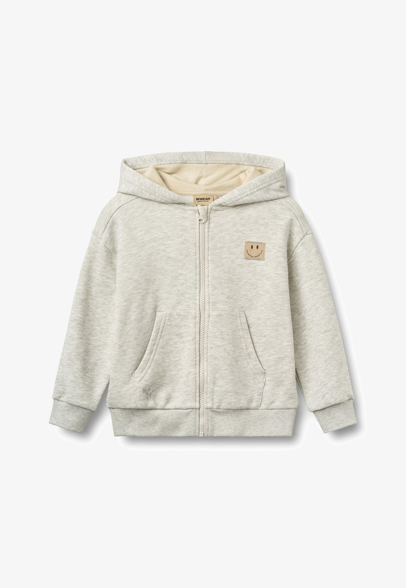 Sweat à capuche gris clair zippé avec poches avant et un petit patch beige avec un visage souriant sur la poitrine.