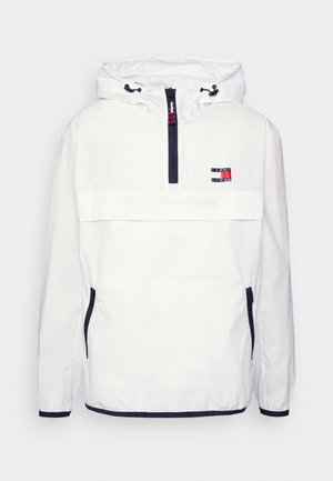 Weißer Kapuzen-Windbreaker mit vorderem Halbreißverschluss, marineblauem Reißverschluss und Taschenakzenten, elastischen Bündchen und Tommy Jeans-Logo auf der Brust.