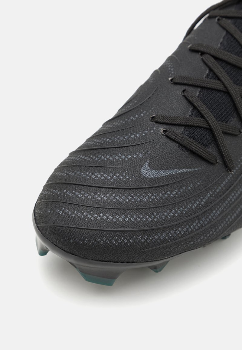 Czarny korki piłkarskie z teksturowaną syntetyczną cholewką, ukośnymi wypustkami, płaskim systemem sznurowania oraz subtelnym logo Nike. Przezroczysta podeszwa z kołkami.