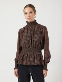 Blouse marron à motif avec un col montant smocké, une taille élastique et des manches froncées. Présente un motif à carreaux aux couleurs contrastées.
