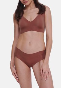 Bruin naadloze bralette en slipset met een zachte, elastische stof; v-hals ontwerp met brede banden en gemiddelde bedekking.