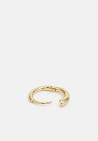 Bague en or avec un écart dans le design, présentant une texture lisse et brillante, ainsi qu'un accent courbé à une extrémité.