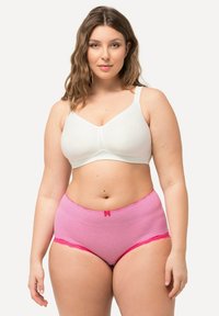 Soutien-gorge blanc, rembourré, avec une texture lisse. Culottes taille haute rayées roses avec des détails en dentelle et un petit nœud au centre devant.