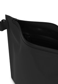 Fekete cipzáras táska sima, matt felülettel; lekerekített formájú, és belső zsebével a rendezett tárolás érdekében.