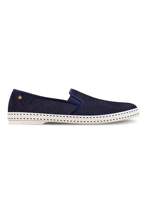 Chaussures slip-on marine avec une tige en mesh perforé, semelle en caoutchouc et semelle intermédiaire tissée blanche avec des coutures noires. Détail du logo discret près du talon.