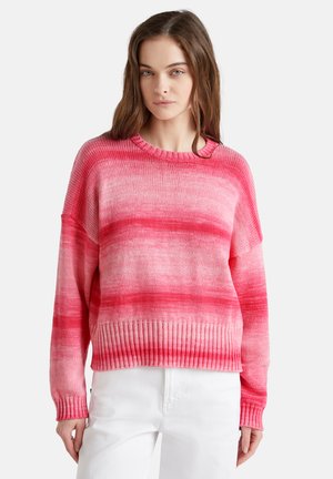 Różowy sweter w paski o różnych odcieniach różowego, z prążkowanym dołem i mankietami, szerokim dekoltem oraz luźnym krojem. Miękka, teksturowana dzianina.