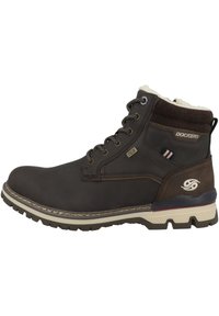 Bottines en cuir marron avec doublure en fourrure blanche, œillets en métal, lacets marron et semelle en caoutchouc avec grip texturé. Logo de la marque visible.