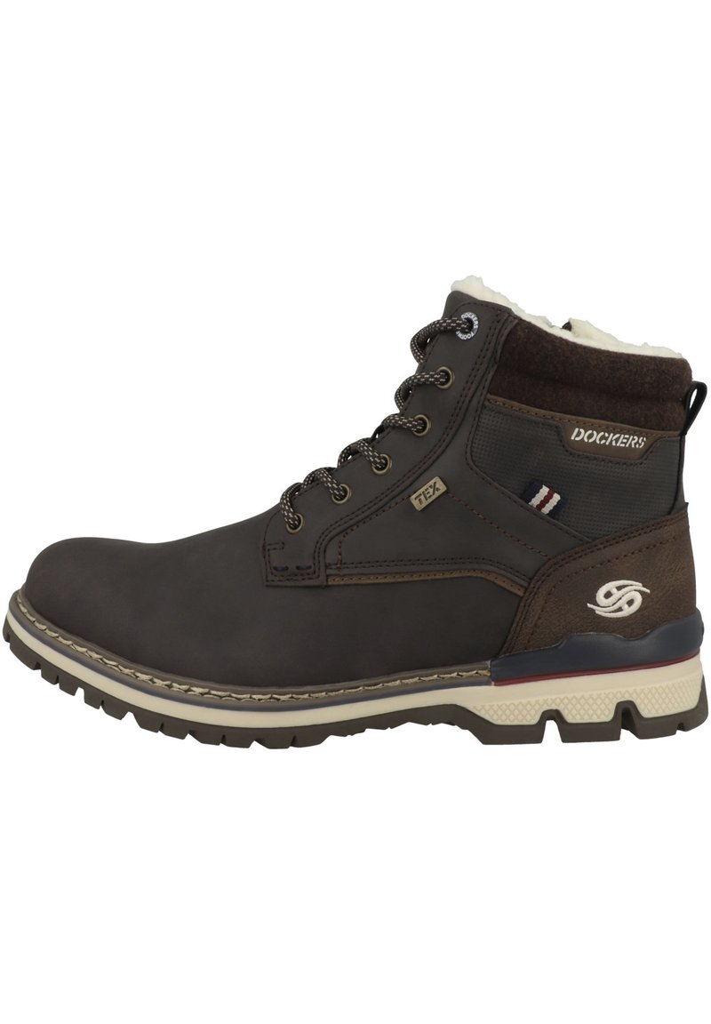 Bottines en cuir marron avec doublure en fourrure blanche, œillets en métal, lacets marron et semelle en caoutchouc avec grip texturé. Logo de la marque visible.