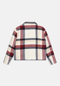 Chaqueta de lana de cuadros en crema, rojo, azul marino y beige. Cuenta con un cuello, mangas largas y una silueta cuadrada con detalles cosidos.