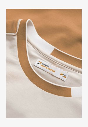 Comfortabel t-shirt met een lichtbeige lichaam en bruine accenten. Heeft een ronde halslijn met witte rand en een label dat maat en merk aangeeft.
