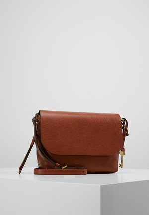 Sac bandoulière en cuir marron texturé avec fermeture à rabat et sangle réglable, présenté sur une surface blanche avec un fond uni.