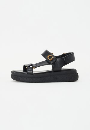 Sandali con zeppa in pelle nera, caratterizzati da punta aperta, cinturini regolabili, dettagli in hardware dorato e suola in gomma texturizzata.