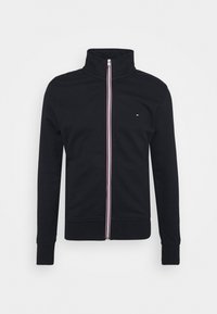 Czarna bluza na zamek z wysokim kołnierzem oraz czerwono-białymi paskami wzdłuż zamka. Posiada ściągacze na mankietach i dole.