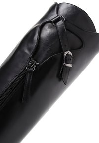 Black leather bag with a slim cylindrical shape, featuring a silver zipper, strap detail, and buckle accent. Smooth texture, minimal design.