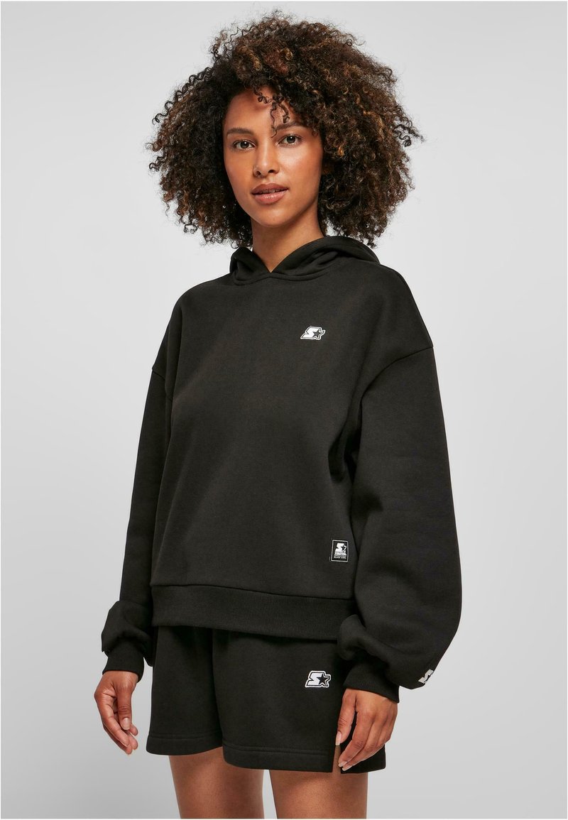 Sudadera negra con capucha, puños acanalados y pantalones cortos negros a juego. Presenta acentos de logo en ambas prendas, fabricadas en un tejido suave.