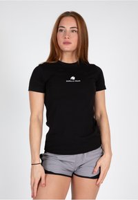 Melnā piegulošā T-krekls no kokvilnas ar īsām piedurknēm, uz krūtīm ar balto "Gorilla Wear" logotipu. Gluda tekstūra, apaļa apkakle.