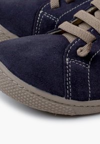 Scarpe di camoscio blu navy con suole in gomma testurizzata, caratterizzate da lacci beige e cuciture a contrasto lungo le cuciture. Design con punta rotonda.