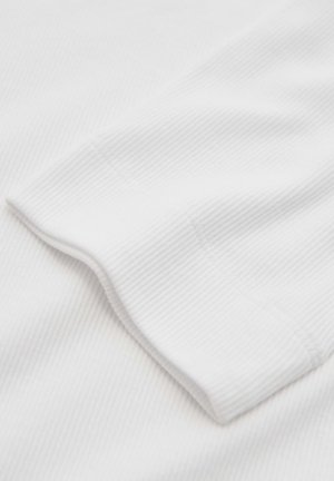 Weißer strukturierter Stoff mit einem gerippten Muster und einem gefalteten Ärmelrand. Das Material wirkt weich und leicht.