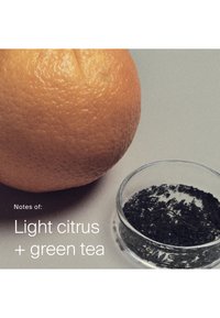 Grapefruit en een kleine doorzichtige kom gevuld met losse groene theebladeren op een lichte ondergrond met tekst die lichte citrus- en groene theetonen aangeeft.