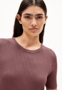 Rippenshirt mit kurzen Ärmeln in mauve. Verfügt über einen runden Halsausschnitt mit einem strukturierten Muster. Der Stoff wirkt weich und eng anliegend.
