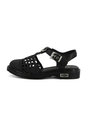 Sandalo intrecciato nero con design aperto. Fibbia alla caviglia e suola in gomma texturizzata per una buona presa. Tacco flat.