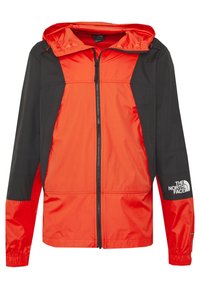 Červeno-černá větrovka se zipem vpředu, nastavitelnou kapucí a elastickými manžetami. Na pravém rukávu je logo.