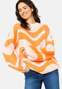 Gehaakte trui met golvende patronen in oranje, roze en roomkleur. Loose fit, ribbelboorden en -zoom, zachte textuur, ronde halslijn.