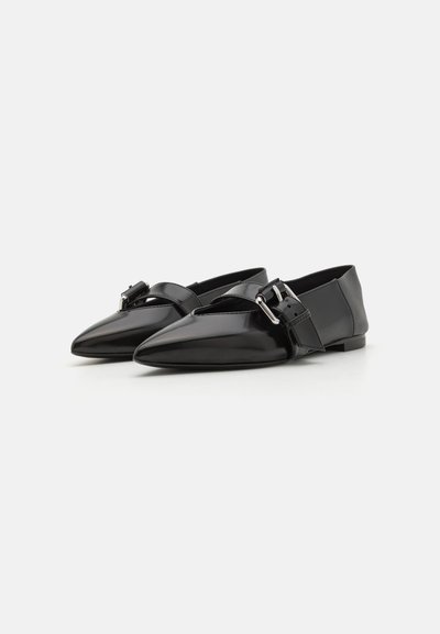 Black patent leather flats with a pointed toe and a cross strap featuring a metallic buckle. Smooth texture and minimalistic design.