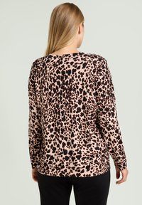 Langærmet top med leopardprint i beige og sort, med rund halsudskæring og en afslappet pasform, lavet af blødt, tekstureret stof.