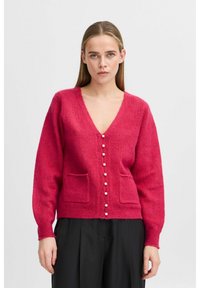 Rozā v-veida kardigāns ar garām piedurknēm, ar teksturētu adījumu, divām priekšējām kabatām un baltām pogām centrā.