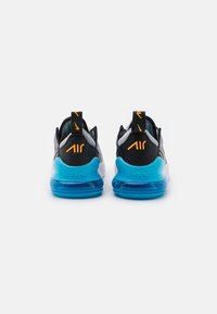 Zapatillas deportivas en negro y gris con parte superior de punto texturizado, suela de amortiguación de aire en azul brillante y marcas en naranja en el talón y las asas.