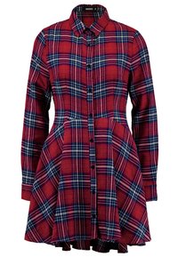 Vestito camicia a scacchi rossi con maniche lunghe, chiusura con bottoni frontale, colletto e gonna svasata. Presenta un motivo a scacchi bianco e blu navy.