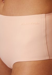 Slip alto in rosa chiaro realizzato in tessuto morbido, con un logo sottile impressa sulla cintura. Design senza cuciture con dettagli minimi.