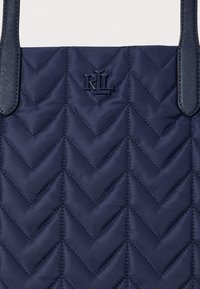 Granatowa pikowana torba z nylonu o wzorze w jodełkę i wytłoczonym logo "RL". Posiada gładkie uchwyty i fakturowane wykończenie.