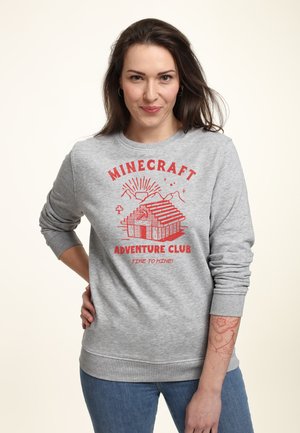 Szary sweatshirt z czerwonym napisem graficznym "MINECRAFT ADVENTURE CLUB" oraz ilustracją blokowej struktury, z prążkowanymi mankietami i dołem.