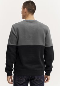 Fleece sweatshirt met een kleurblockontwerp in grijs en zwart, met ribgebreide manchetten en onderrand, en een klassieke ronde hals.