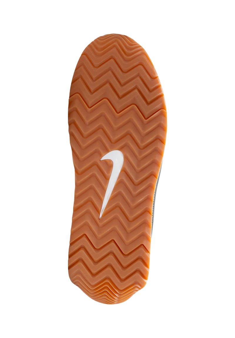 Suela de zapato Nike con un patrón de tracción en zigzag en goma naranja y el logo Swoosh en blanco. El borde es redondeado para una mejor agarre.