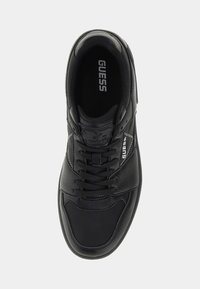Scarpa sportiva nera con tomaia in pelle testurizzata, design con lacci, colletto imbottito e suola in gomma. Presenta il logo "GUESS" sulla linguetta e sul lato.