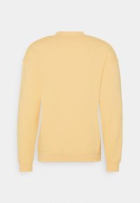 Gele sweatshirts met lange mouwen, een ronde hals en een minimalistisch ontwerp. Zacht materiaal met ribbels bij de manchetten en zoom.