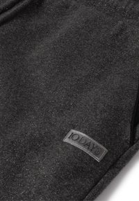 Schwarzer Textilstoff mit einem subtilen Schimmer, ausgestattet mit einem grauen Etikett, das "10DAYS" liest und sich unten rechts befindet.