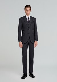 Grå skræddersyet jakkesæt med en slim fit, der har en klippet revers, to knaplukninger og sidelommer. Kombinationen inkluderer et mønstret slips og en hvid lommetørklæde.