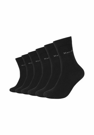 Sei paia di calzini neri crew disposti uno accanto all'altro, ognuno con polsino a coste e logo bianco discreto vicino alla parte superiore.
