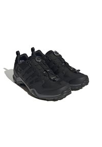 Zapatos deportivos negros con una parte superior texturizada, sistema de cordones con cierre de seguro, puntera reforzada y suela de goma duradera para tracción.