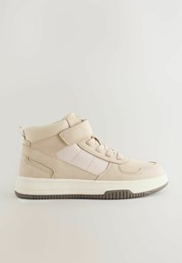 Baskets montantes beiges avec une sangle Velcro, des panneaux texturés, un bout rond et une semelle blanche. Présente des détails de couture et un accent à motifs.