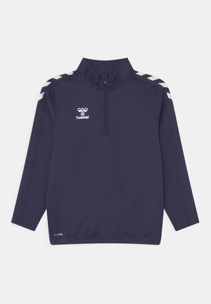 Marineblå langærmet pullover med en kvart lynlås, har hvide chevron-detaljer på skuldrene og et logo på brystet, fremstillet af glat stof.