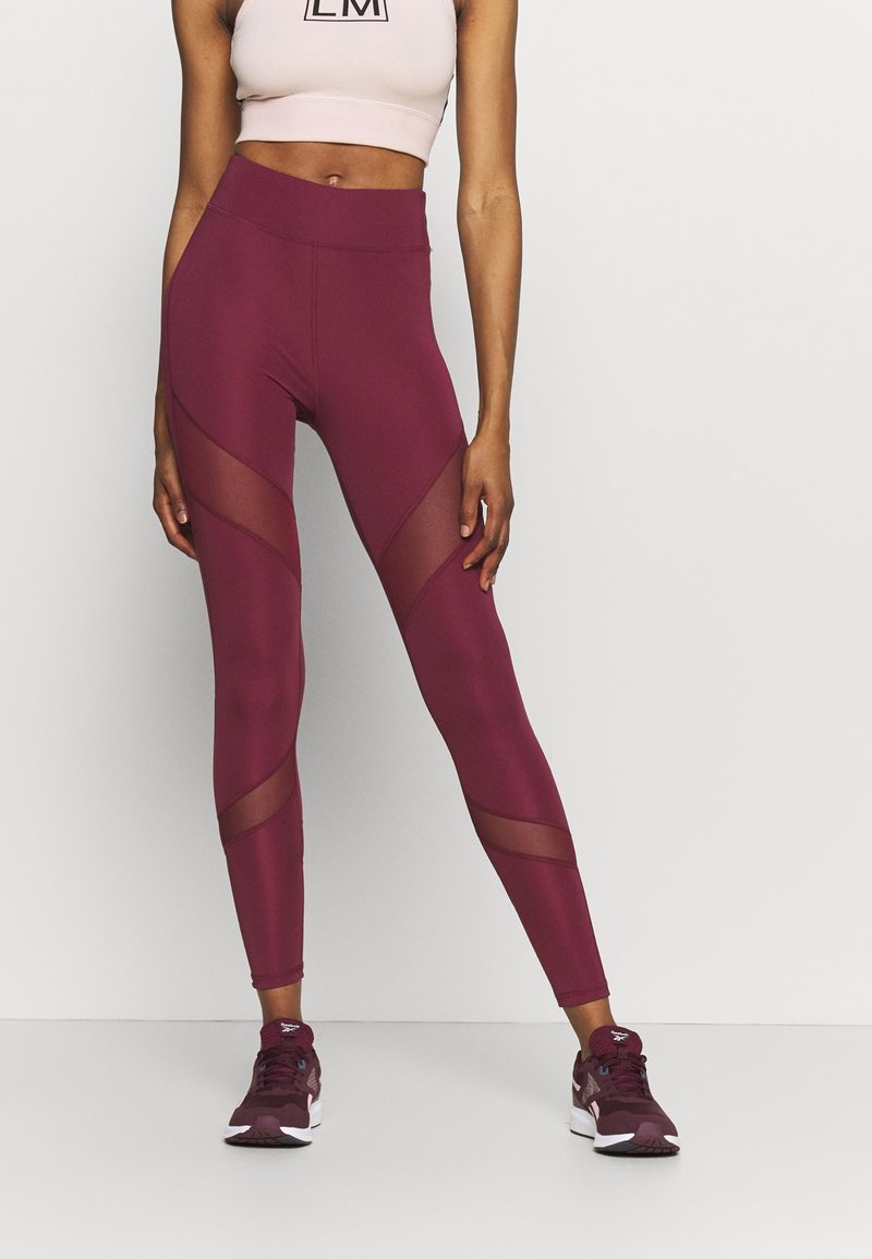 Leggings burdeos con paneles de malla y una cintura alta, combinados con un top corto rosa claro, adecuados para ropa deportiva.