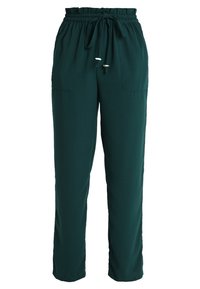 Pantalons verts amples avec une taille élastique et un cordon de serrage ajustable. Deux poches avant et une texture de tissu lisse et léger.