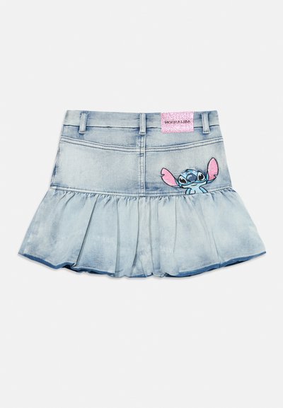 Jupe en denim bleu clair, avec un ourlet froncé, des bords effilochés et un personnage Stitch brodé sur le devant. Étiquette en forme de logo rose pailleté.