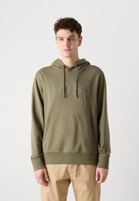 Felpa khaki con tasca frontale, cappuccio con coulisse e logo "BOSS" in rilievo. Tessuto liscio e polsini aderenti, abbinata a pantaloni beige.